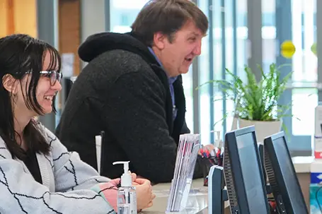 Two students smiling sitting at a table
