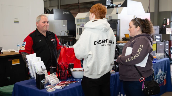 CTE showcase Two CTE showcase attendees talk to a CCC automotive instructor at a booth